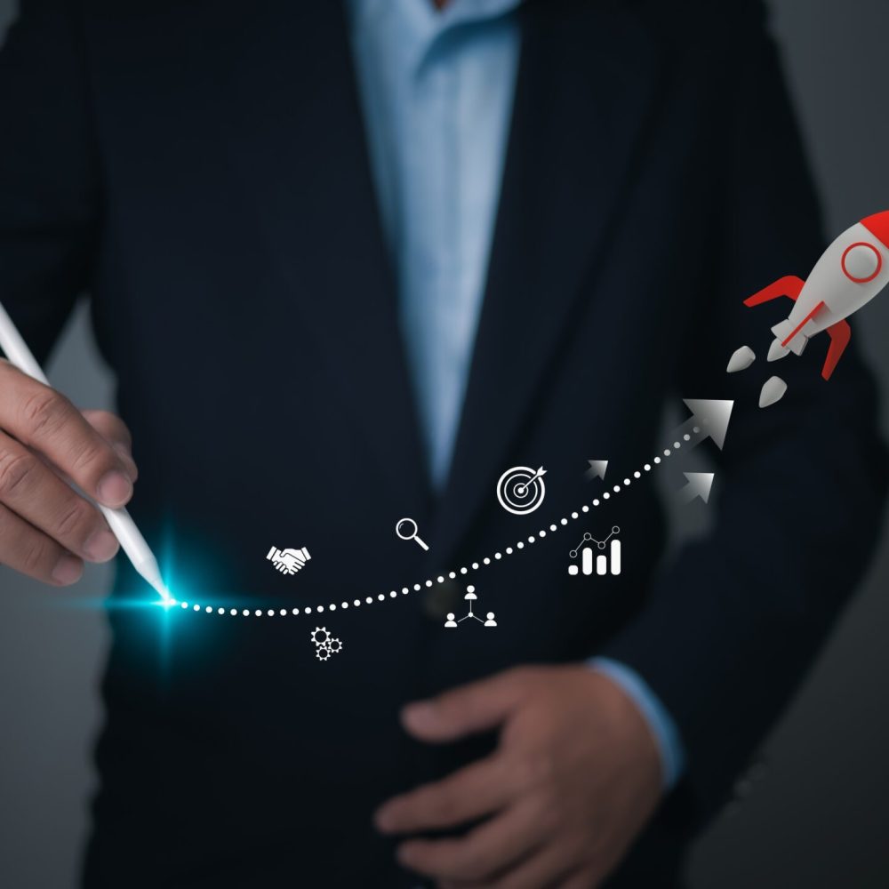 A businessman uses a stylus to chart a vibrant, glowing dotted path for a rocket, symbolizing the trajectory of business growth, strategic planning, and achieving ambitious goals.